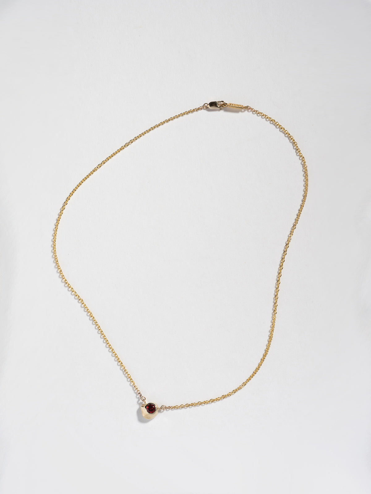 Product image of FARIS KIRA Necklace in 14k gold with garnet, full product shown on white background,  front view