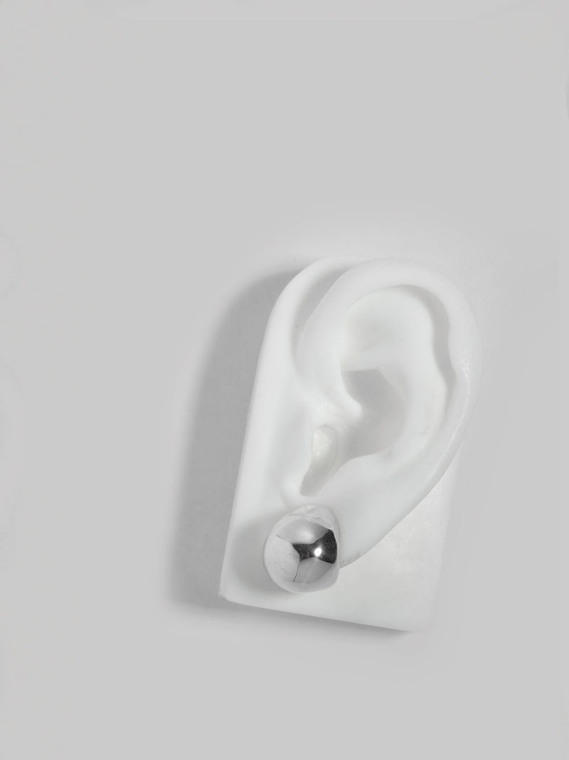 Product image of FARIS SUMO Stud in sterling silver, shown on white silicon ear display (front view)