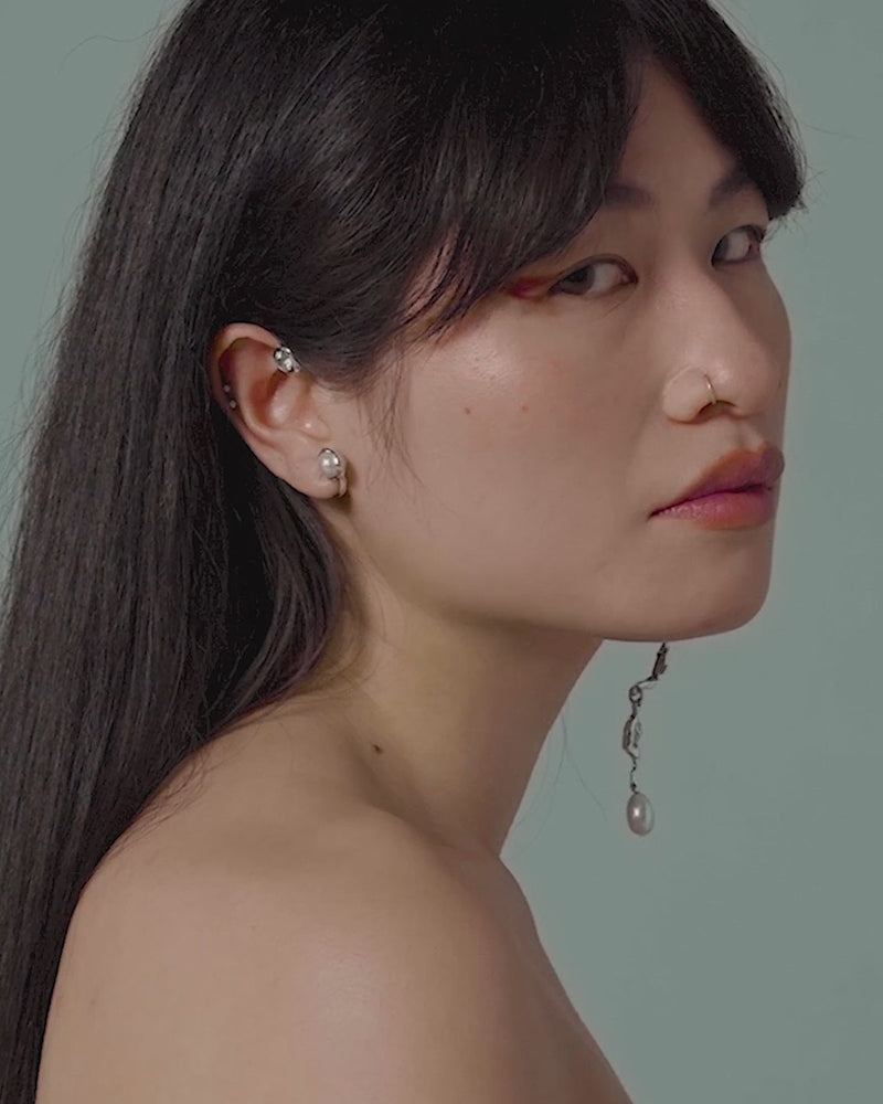 Moving image of model wearing BI Ear Cuff in sterling silver with topaz and freshwater pearl, ELEKTRA dangling from opposite ear