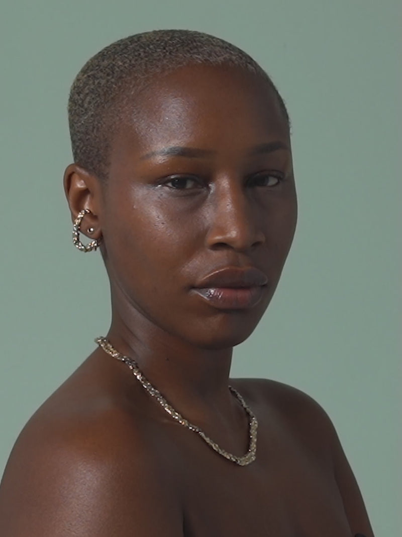 Short clip of FARIS BRUTO Collar (19") in gold-plated bronze shown on model. Styled with ROCA Hang in gold-plated bronze and EGG GEM Stud in 14k with garnet