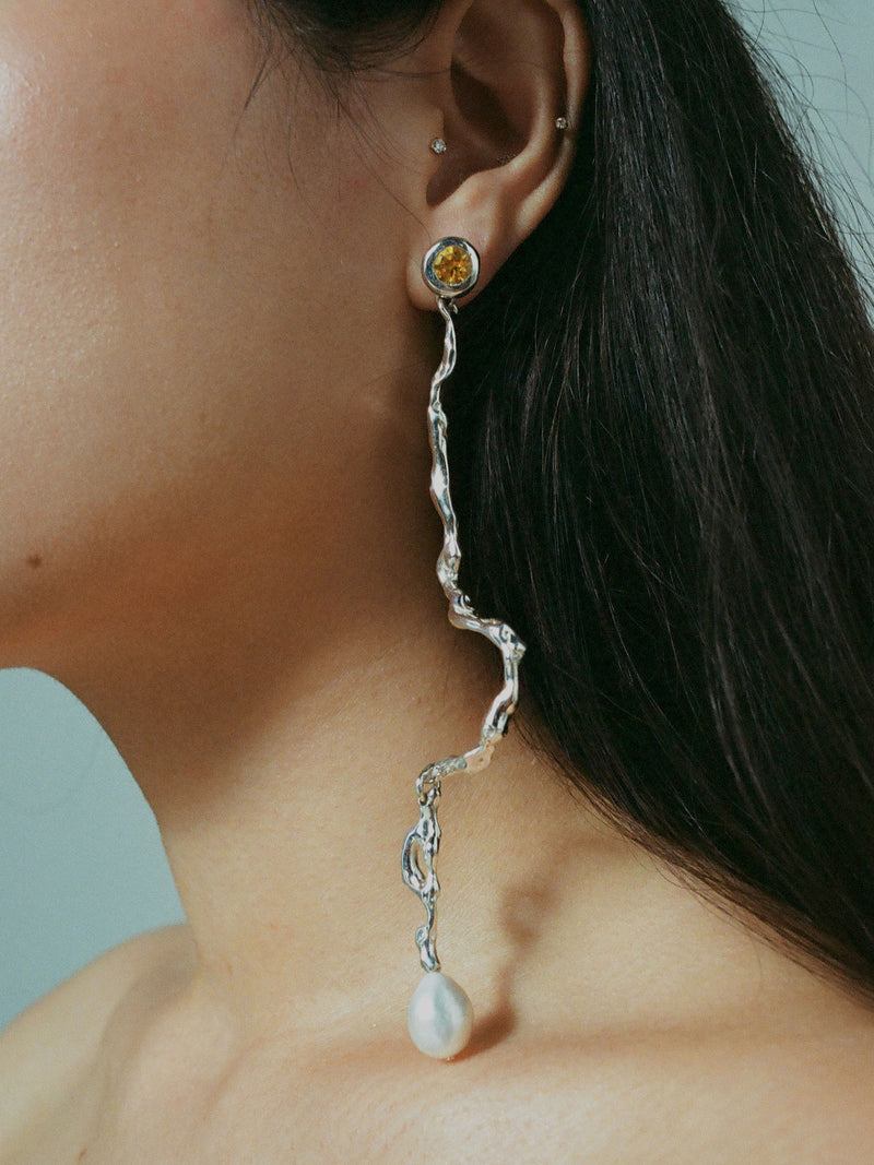 Model wearing ELEKTRA with diamond cut citrine and a freshwater pearl
