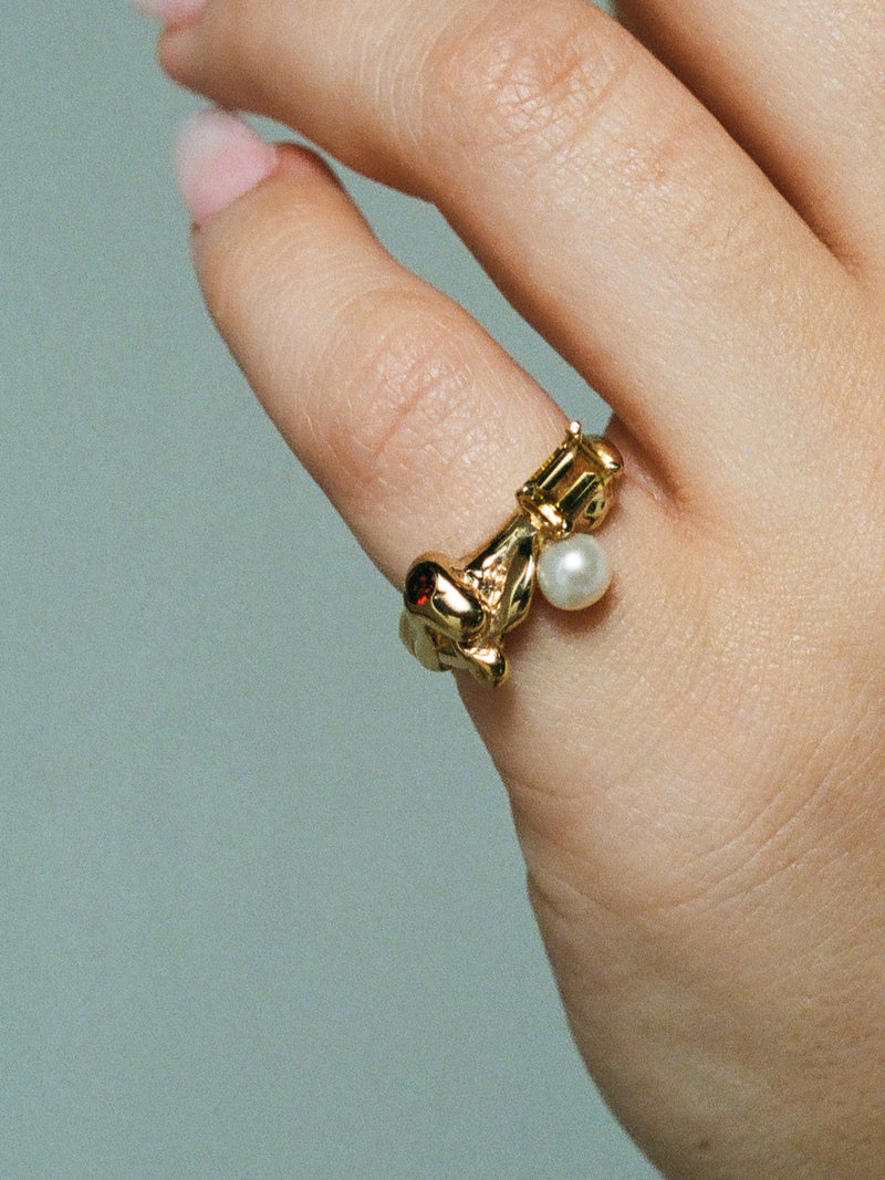 Close up image of FARIS MENAGE Ring in gold-plated bronze with citrine, garnet, and freshwater pearl. Shown on model