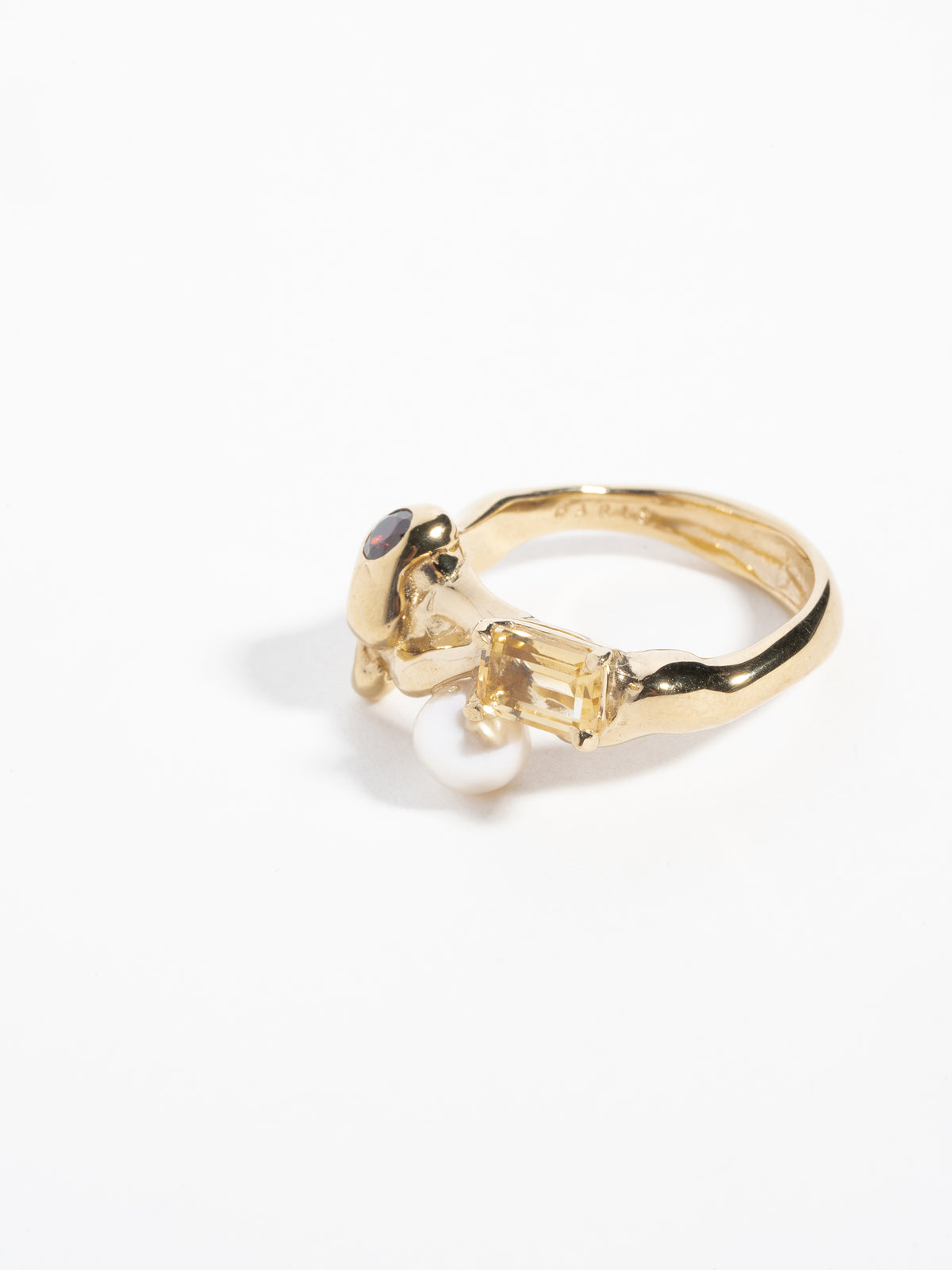 Side view close-up image of FARIS MENAGE Ring in gold-plated bronze with citrine, garnet, and freshwater pearl. 