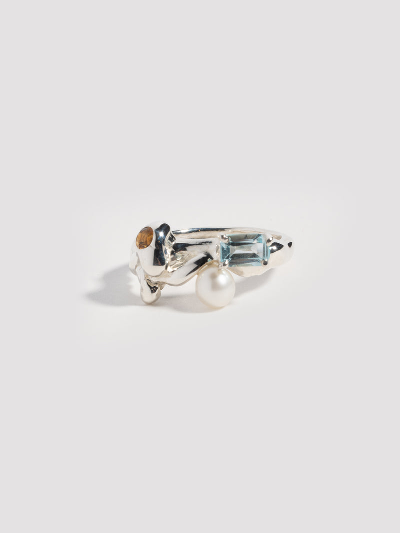 FARIS MENAGE Ring in sterling silver with prong-set emerald-cut topaz, flush-set round, diamond-cut citrine, and freshwater pearl. Front view.