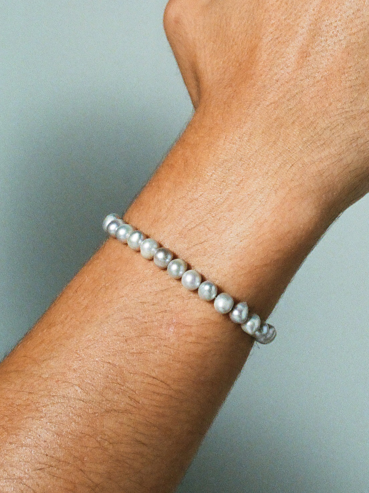 Close up image of string of pearls used in FARIS PATTA Bracelet in sterling silver, shown on model