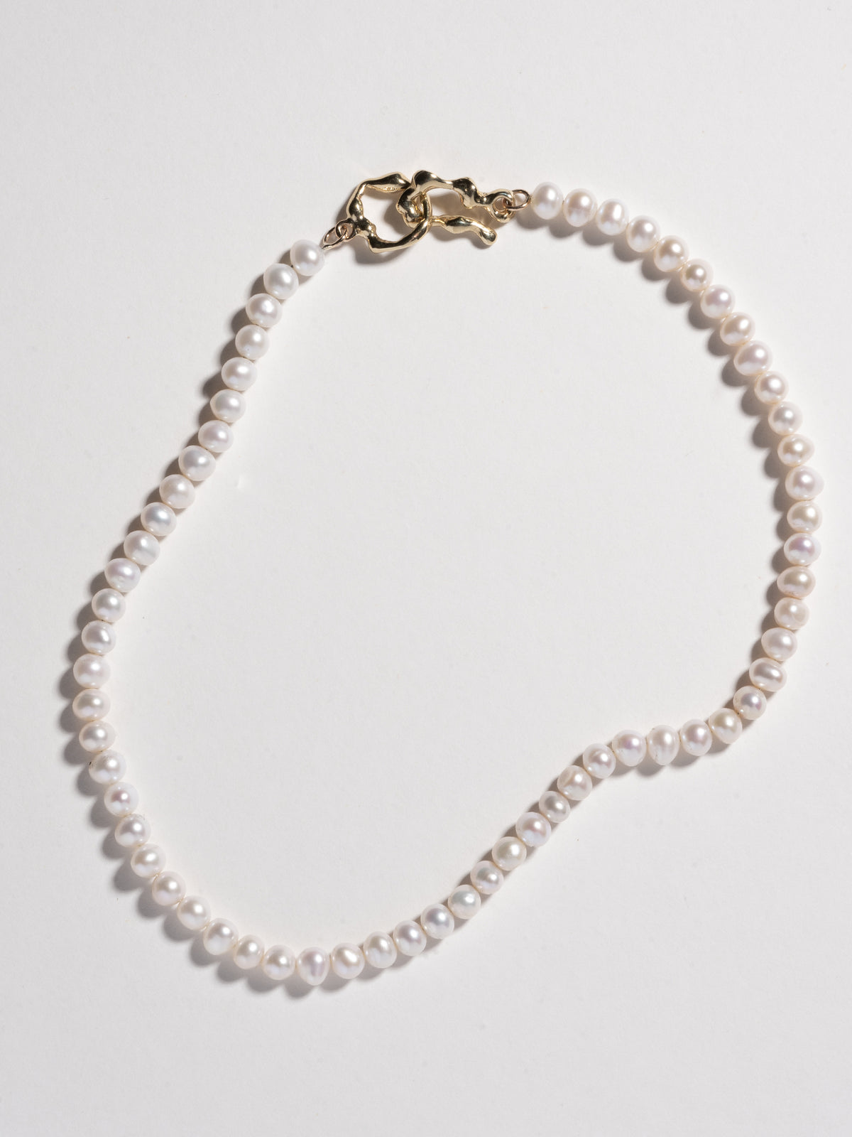 EGG Collar in 14k gold plate closing a string of pearls