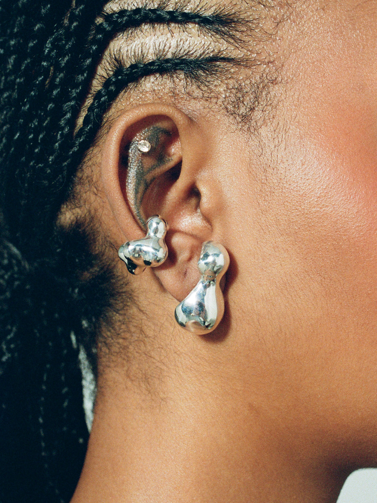 Close up image of FARIS BOLO Stud in sterling silver, shown on model. Styled with KUMO Ear Cuff in sterling silver