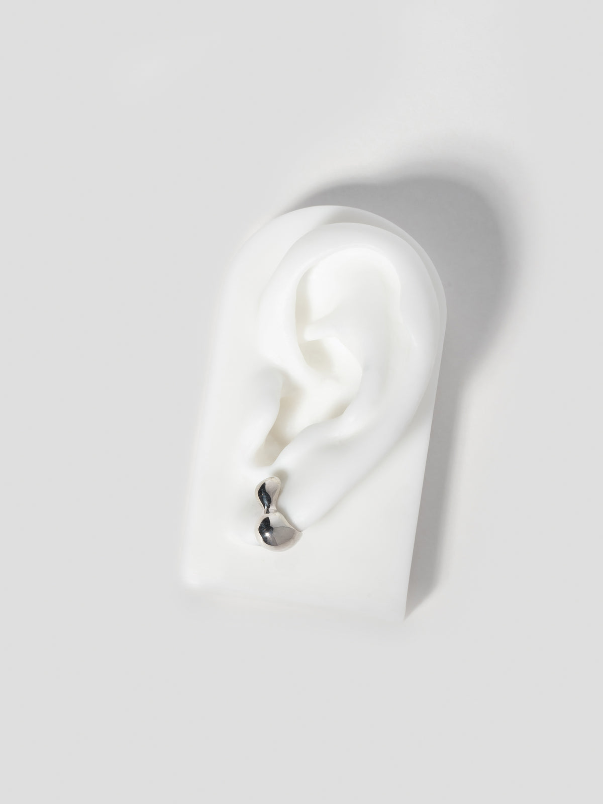Product image of FARIS CHAMELLE Stud in Sterling Silver, shown on white silicone ear display.