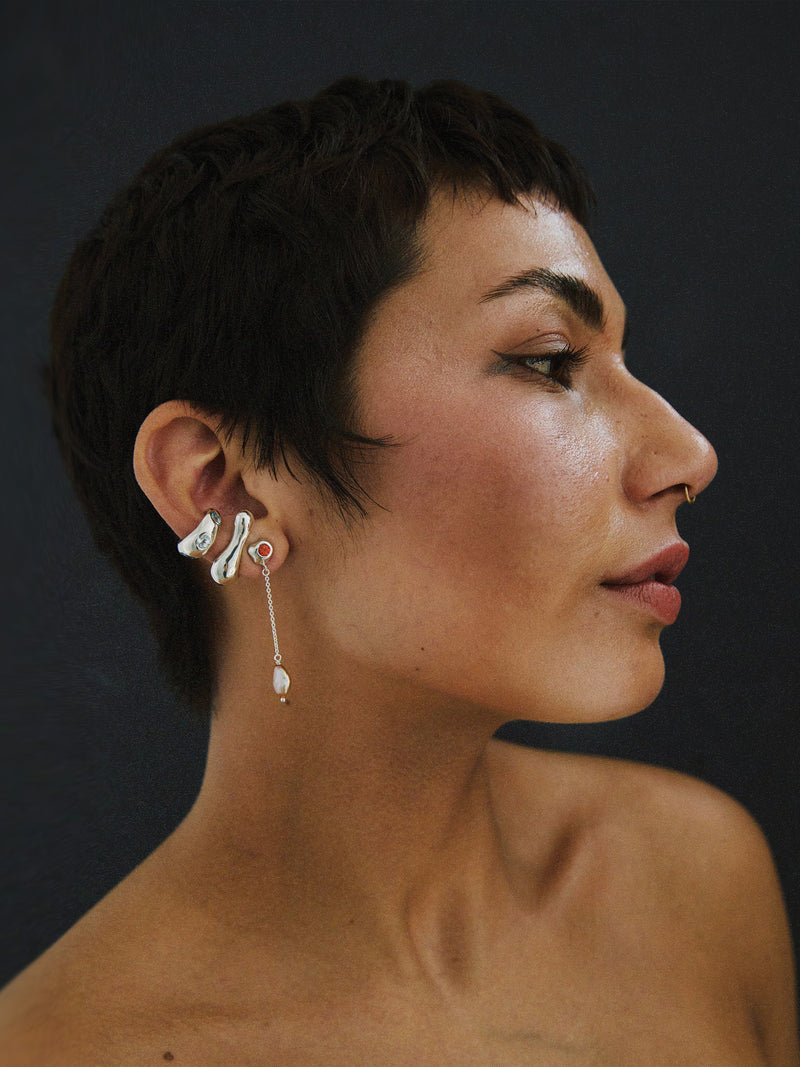 FARIS REST Stud in sterling silver worn on model, styled with the long side of KIRA Drops in sterling silver with lab-created orange sapphire, and GROSSO GEM Ear cuff in sterling silver with topaz