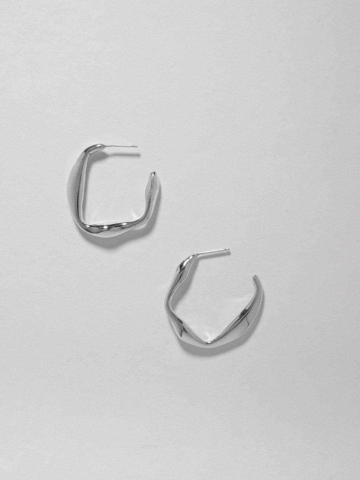 Product image of FARIS ONDA Hoop Small in sterling silver. Hoops shown side by side, staggered