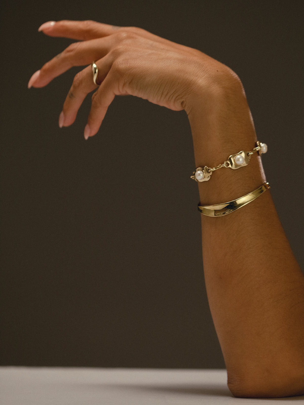 RIVER ring, OSTRA bracelet, and RIVER cuff in gold plated bronze on model