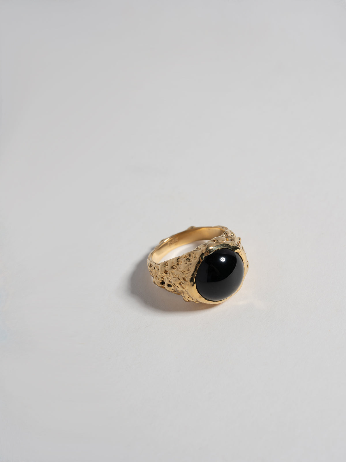 Close up product shot of FARIS ROCA BAM Ring in gold-plated bronze with onyx embedded at face. 