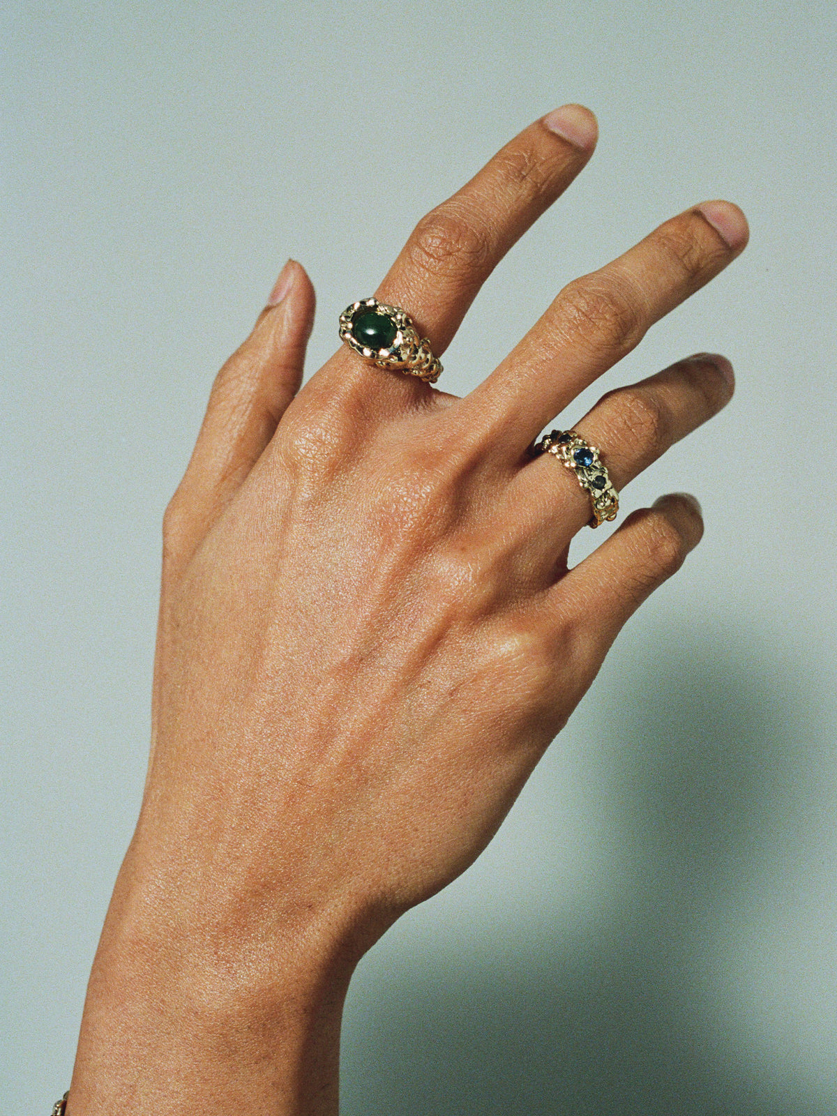 FARIS ROCA EYE Ring in gold-plated bronze with jade worn on model. Styled with ROCA GEM Band in gold-plated bronze with lab-created blue and green sapphires