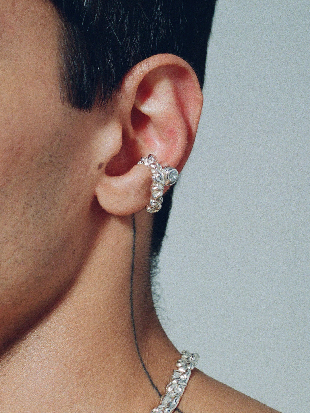 FARIS ROCA GEM Ear Cuff in sterling silver with topaz worn on male model. Styled with BRUTO Collar in sterling silver