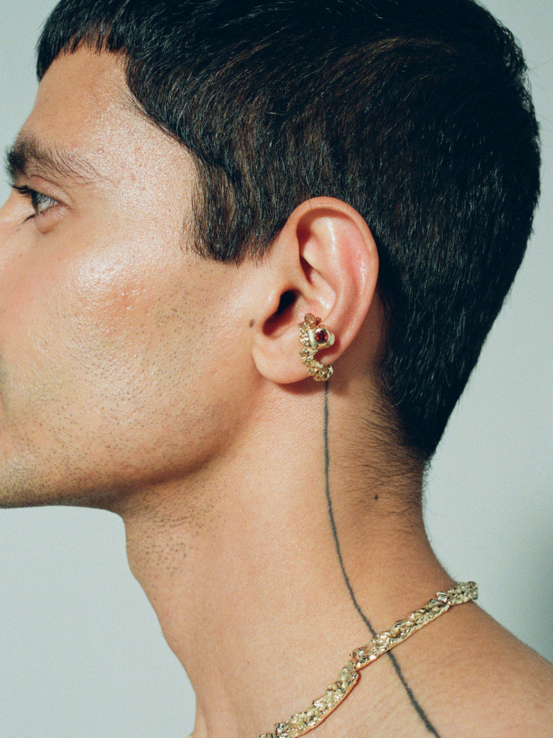 FARIS ROCA GEM Ear Cuff in gold-plated bronze with garnet worn on male model. Styled with BRUTO Collar in gold-plated bronze