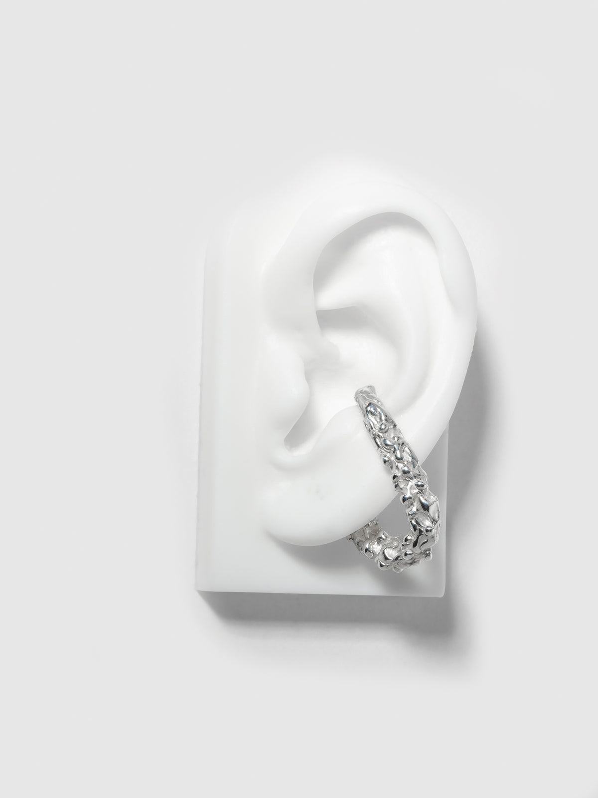 Product image of FARIS ROCA Hang in sterling silver (left ear orientation), shown on silicone ear.