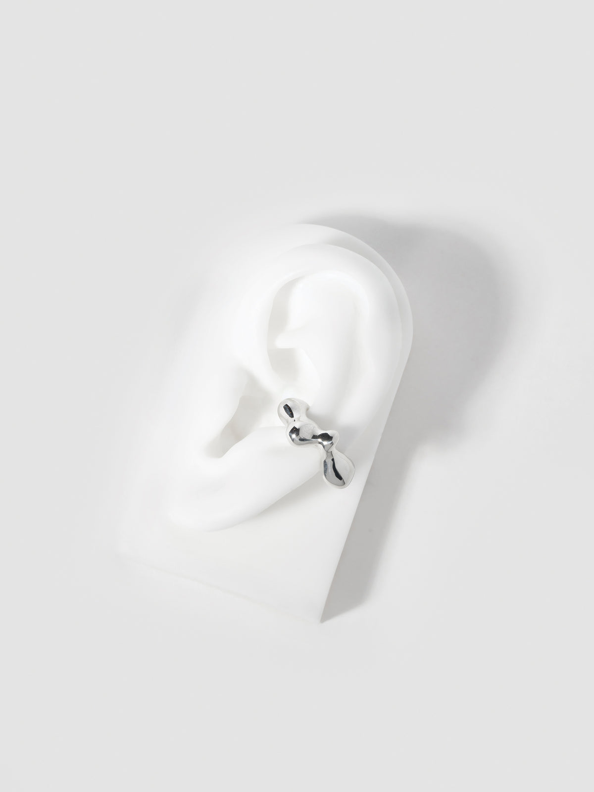 Product image of FARIS SEEP Ear Cuff in sterling silver shown on silicone ear