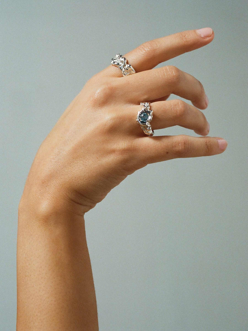 FARIS SPELL Ring in sterling silver with topaz, shown on model, worn on ring finger. Styled with LAVA Band 10mm in sterling silver, worn on index finger