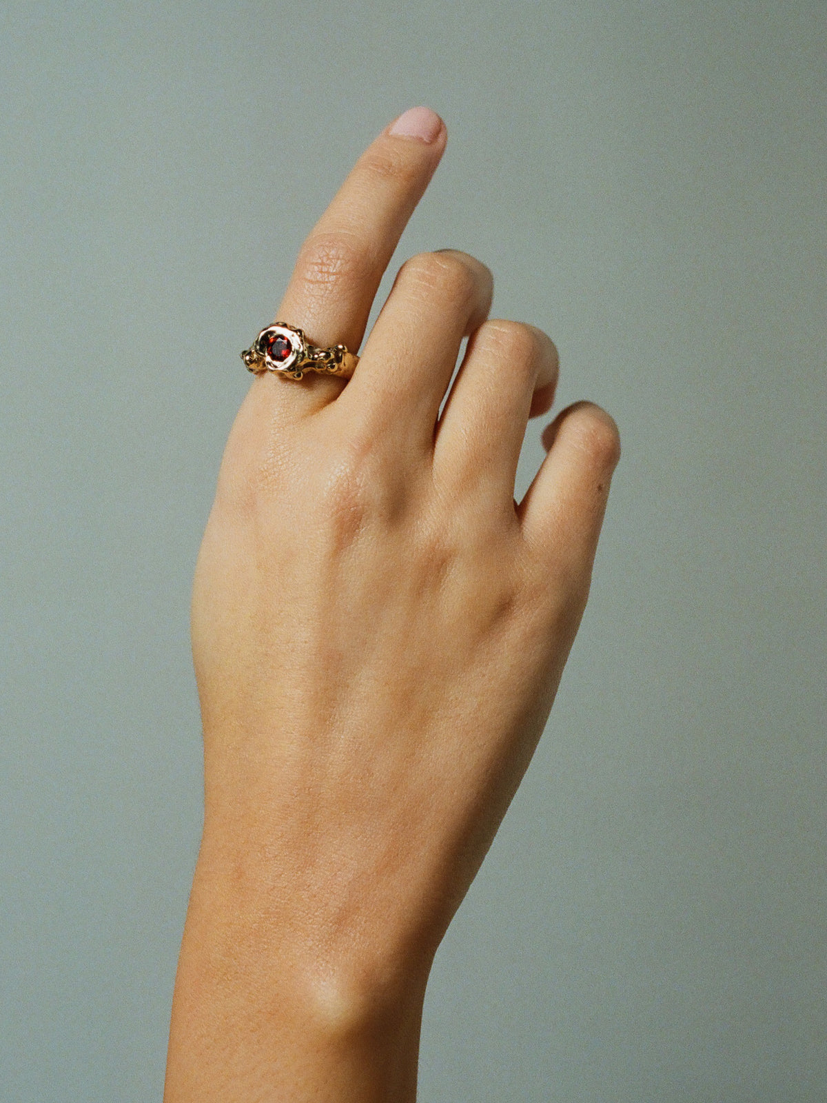 FARIS SPELL Ring in Gold-Plated Bronze with garnet shown on model