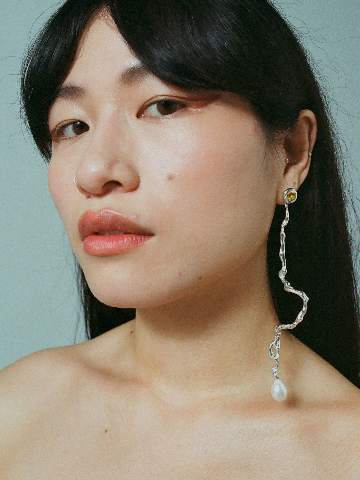 Model wearing ELEKTRA with diamond cut citrine and a freshwater pearl