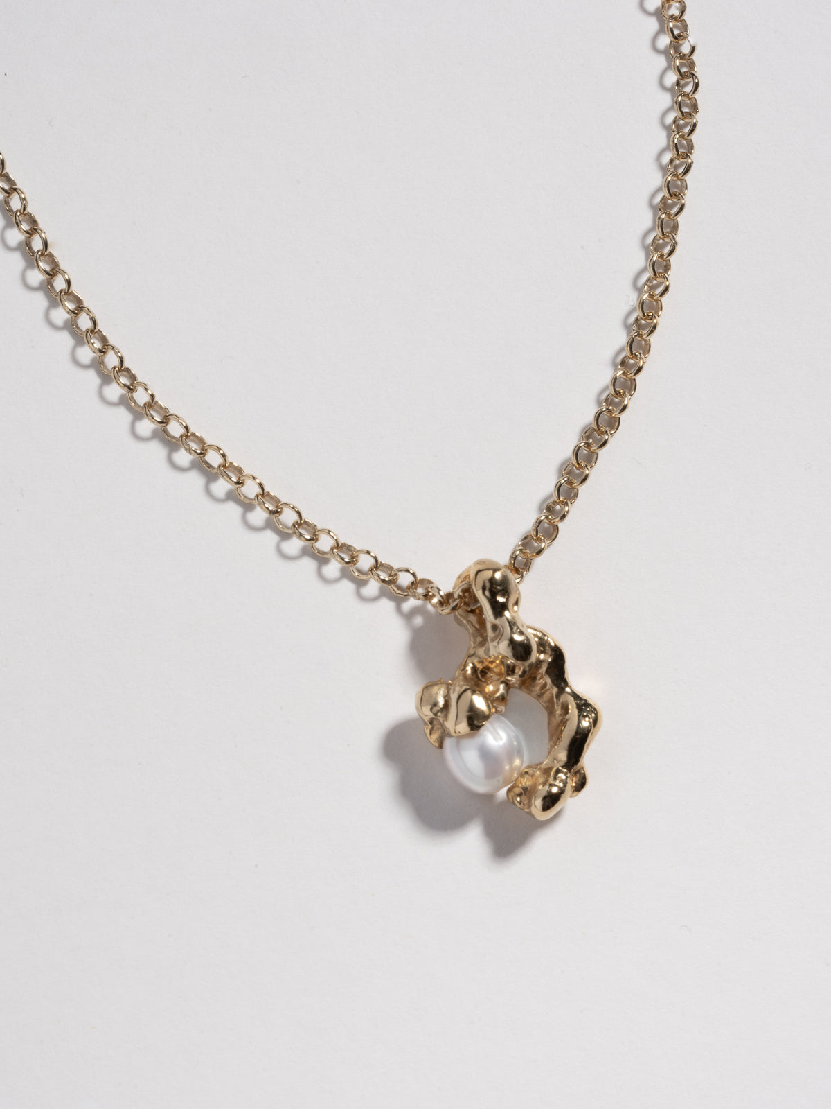 Close up image of 14k gold plated FELLINI Necklace pendant with white freshwater pearl