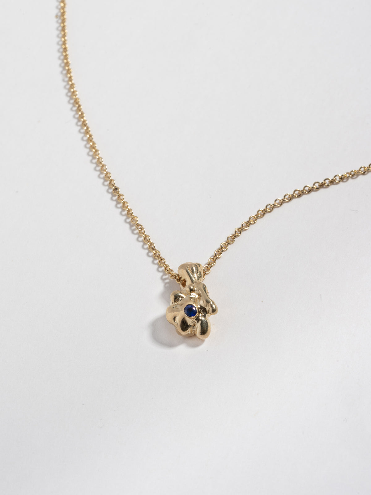 Close up of 14k gold plated GOBBO Necklace pendant with blue sapphire