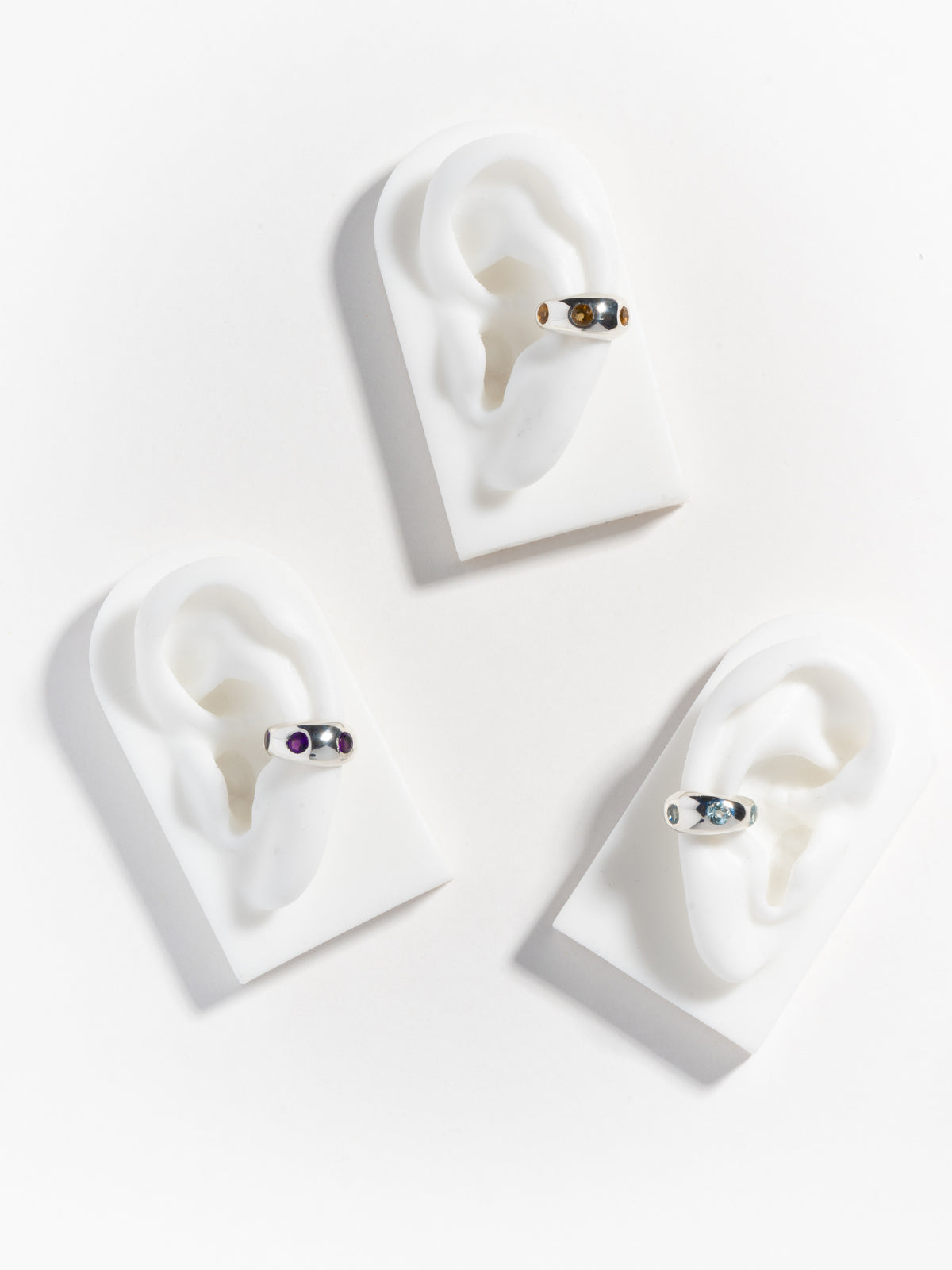 All three variants of FARIS GROSSO Gem ear cuffs in sterling silver (top: citrine; left: purple amethyst; right: topaz)