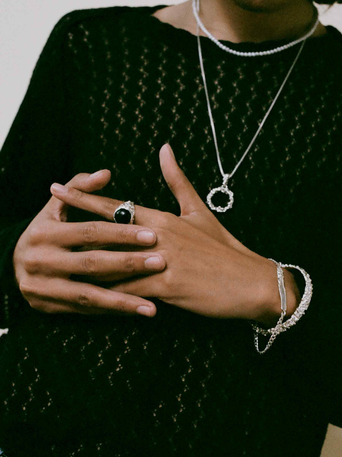 FARIS ROCA BAM Ring in sterling silver and onyx shown on model, styled with ROCA LOOP Necklace in sterling silver, SEED Necklace in 14k with white pearls, ROCA TAG Bracelet in sterling silver, and ROCA Cuff in sterling silver